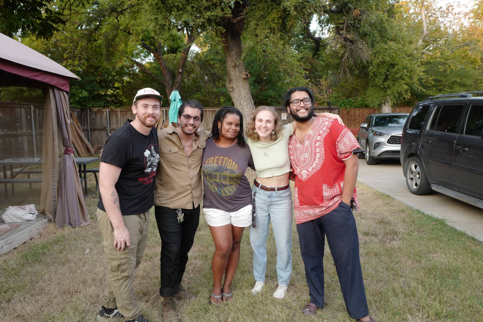 Hope with four friends from a film crew, arms around each other in a backyard at golden hour
