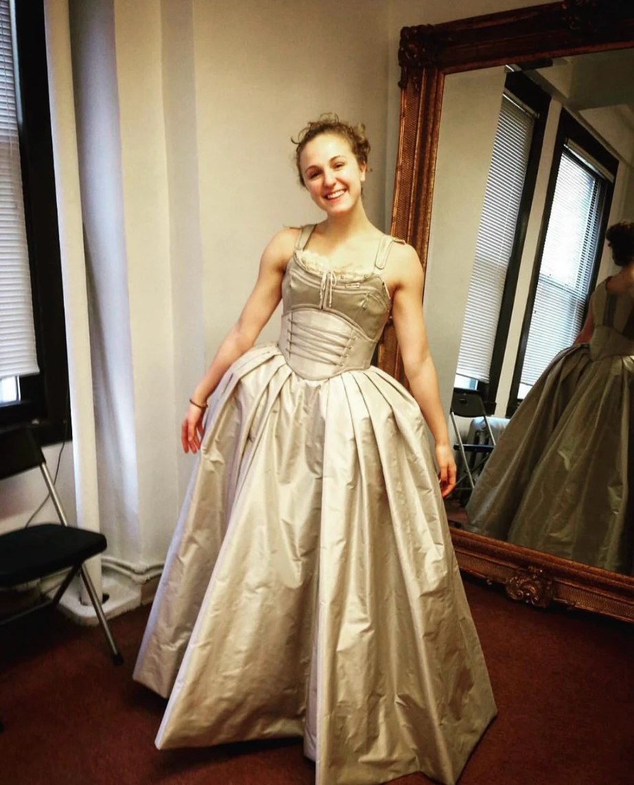 Hope in a cream period gown at a costume fitting